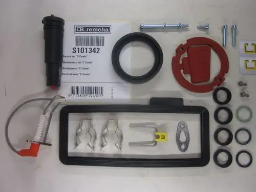 Service-Kit von Remeha mit verschiedenen Dichtungen, Kleinteilen und einer roten Abdeckung, zur Wartung des C Combi Heizsystems. Enthält auch eine Anleitung und diverse Schrauben.